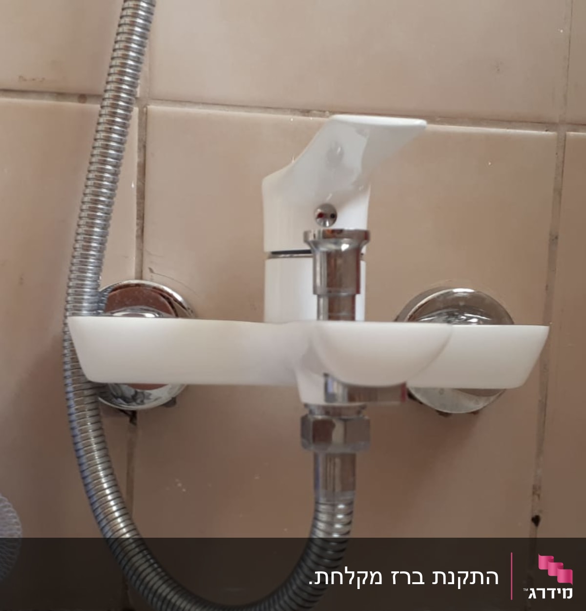 ברז מים עם צינור מתכת בחדר אמבטיה